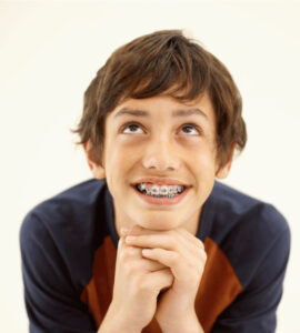 smiling child with braces looking up